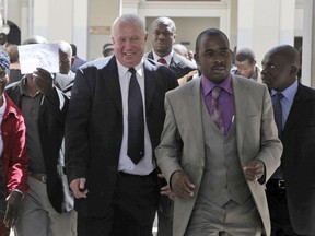 FILE - In this May, 10, 2010, file photo, Roy Bennett, center left, leaves the High Court in Harare, Zimbabwe, after he was acquitted of terrorism charges. New Mexico State Police said Thursday, Jan. 18 2018, that Zimbabwean opposition leader Roy Bennett died in helicopter crash. The crash on Wednesday, Jan. 17, carrying Bennett and five others went down in a mountainous rural area of northern New Mexico.