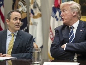 FILE - In this Thursday, Jan. 11, 2018, file photo, President Donald Trump, right, and Kentucky Gov. Matt Bevin, left, talk during a prison reform roundtable in the Roosevelt Room of the Washington. Kentucky has become the first state to win approval from the Trump administration requiring many of its Medicaid recipients to work to receive coverage. The Trump administration gave the go ahead Friday, Jan. 12, 2018.