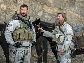 This image released by Warner Bros. Entertainment shows Chris Hemsworth, left, and Thad Luckinbill in a scene from "12 Strong."