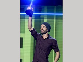 FILE - In this Oct. 26, 2017 file photo, Enrique Iglesias accepts the artist of the year award at the Latin American Music Awards in Los Angeles. Iglesias is suing Universal Music Group in a dispute over how much he is paid for songs played on streaming music services.