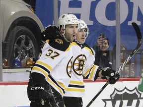 Boston Bruins' Patrice Bergeron (37) celebrates with teammate Brad Marchand after scoring a goal during the first period of an NHL hockey game against the New York Islanders, Thursday, Jan. 18, 2018, in New York.