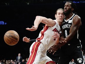 Miami Heat's Kelly Olynyk (9) passes the ball away from Brooklyn Nets' DeMarre Carroll (9) during the first half of an NBA basketball game Friday, Jan. 19, 2018, in New York.
