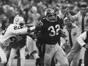 FILE - In this Dec. 23, 1972, file photo, Franco Harris (32) of the Pittsburgh Steelers eludes a tackle by Jimmy Warren of the Oakland Raiders on a 42-yard run to score the winning touchdown in the American Conference playoff game in Pittsburgh. The Minnesota Vikings' last-second playoff win over the New Orleans Saints brought back memories of another desperation playoff touchdown, the Immaculate Reception.