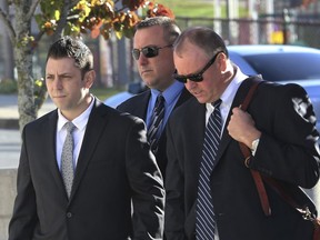 FILE- In this Nov. 7, 2016, file photo, Anthony Carelli, left, arrives to court in White Plains, N.Y. The civil rights probe into the death of a mentally ill black man who accidentally set off his emergency medical alert device and was fatally shot by Carelli, a suburban New York police officer who responded, has been closed without charges. Acting U.S. Attorney Joon Kim said in a statement Thursday, Jan. 4, 2018, that there was insufficient evidence for criminal charges in the shooting of Kenneth Chamberlain.