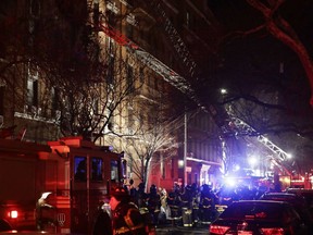 FILE- In this Dec. 28, 2017, file photo, firefighters respond to a deadly building fire in the Bronx borough of New York. Police say Holt Francis was critically injured in the apartment building fire and died at a hospital on Thursday, Jan. 4, 2018. It was one of New York City's deadliest fires in decades.