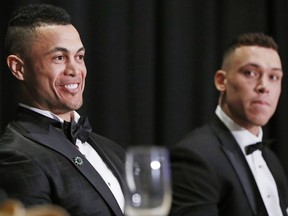 National League Most Valuable Player Giancarlo Stanton, left, and American League Rookie of the Year Aaron Judge listen too speakers during the New York Chapter of the Baseball Writers' Association of America annual dinner in New York, Sunday, Jan. 28, 2018, where both picked up their awards.