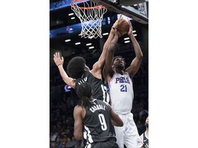 Philadelphia 76ers center Joel Embiid (21) goes to the basket against Brooklyn Nets forward DeMarre Carroll (9) and center Jarrett Allen during the first half of an NBA basketball game, Wednesday, Jan. 31, 2018, in New York.