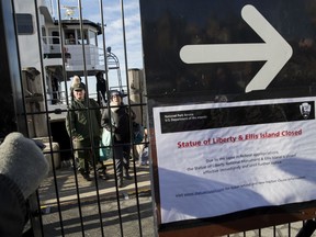 People who work at the Statue of Liberty and Ellis Island disembark from a ferry at Battery Park, Saturday, Jan. 20, 2018, in New York. The National Park Service announced that the Statue of Liberty and Ellis Island would be closed Saturday "due to a lapse in appropriations." Late Friday, the Senate failed to approve legislation to keep the government from shutting down after the midnight deadline.