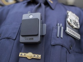 FILE - In this April 27, 2017, file photo, a police officer wears a newly issued body camera at the 34th precinct in New York. A union representing New York City police officers sued the department Tuesday, Jan. 9, 2018, saying its release of body camera footage without a court order violates a state law that makes officer disciplinary records confidential.
