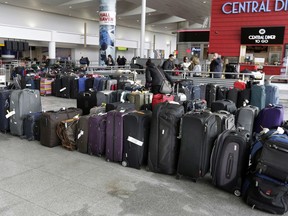 A woman looks through unclaimed baggage at New York's John F. Kennedy Airport Terminal 4, Monday, Jan. 8, 2018. The Port Authority of New York and New Jersey said Monday it will investigate the water pipe break that added to the weather-related delays at Kennedy Airport and will "hold all responsible parties accountable." The agency said there were still some delays on Monday, the day after the pipe break in the privately operated Terminal 4 broke, causing water to flood the terminal and significantly disrupt operations.