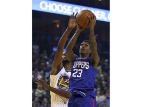 Los Angeles Clippers' Lou Williams (23) shoots past Golden State Warriors' Kevin Durant, left, during the first half of an NBA basketball game Wednesday, Jan. 10, 2018, in Oakland, Calif.