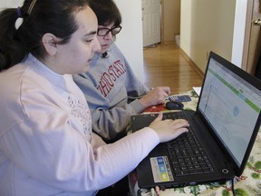 In a Jan. 18, 2018 photo, nineteen-year-old student Chryssoula Stavropoulos, along with her mother Elaine, uses her family's laptop to complete lessons for the Electronic Classroom of Tomorrow, one of the nation's largest online charter schools, from her kitchen in Blacklick, Ohio. Her mother, Elaine, assists Chryssoula, who is autistic. Electronic Classroom of Tomorrow, the giant Ohio online charter school that abruptly closed mid-school-year lost another round of its multifaceted battle with the state over funding but said Tuesday, Jan. 23, 2018 that it's still fighting to reopen, even as many of its 12,000 students are looking for new schools.