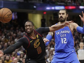 Cleveland Cavaliers' Dwyane Wade (9) loses control of the ball as Oklahoma City Thunder's Steven Adams (12), from New Zealand, defends in the first half of an NBA basketball game, Saturday, Jan. 20, 2018, in Cleveland. The Thunder won 148-124.