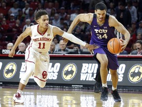 TCU's Kenrich Williams (34) drives the ball away from Oklahoma's Trae Young (11) during the first half of an NCAA college basketball game in Norman, Okla., Saturday, Jan. 13, 2018.