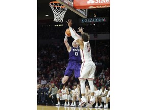 TCU's Jaylen Fisher (0) shoots the ball over Oklahoma's Trae Young (11) during the first half of an NCAA college basketball game in Norman, Okla., Saturday, Jan. 13, 2018.