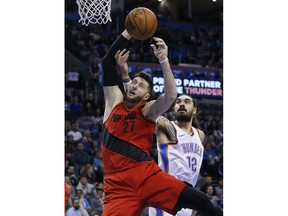 Portland Trail Blazers center Jusuf Nurkic (27) and Oklahoma City Thunder center Steven Adams (12) reach for a rebound during the first quarter of an NBA basketball game in Oklahoma City, Tuesday, Jan. 9, 2018.