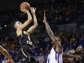 Wichita State guard Landry Shamet, left, shoots over Tulsa forward Martins Igbanu, right, in the first half of an NCAA basketball game in Tulsa, Okla., Saturday, Jan. 13, 2018.