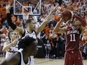 Oklahoma guard Trae Young (11) takes the final shot of overtime in front of Oklahoma State guard Kendall Smith, left, in an NCAA college basketball game against in Stillwater, Okla., Saturday, Jan. 20, 2018. Oklahoma State won 83-81 in overtime.