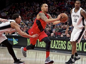 Portland Trail Blazers guard Shabazz Napier, center, dribbles past San Antonio Spurs guard Bryn Forbes, left, and San Antonio Spurs forward LaMarcus Aldridge, right, during the first half of an NBA basketball game in Portland, Ore., Sunday, Jan. 7, 2018.