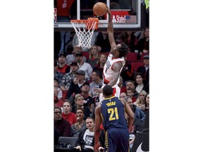 Portland Trail Blazers forward Al-Farouq Aminu, top, dunks over Indiana Pacers forward Thaddeus Young during the first half of an NBA basketball game in Portland, Ore., Thursday, Jan. 18, 2018.