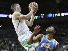Oregon's Payton Pritchard, left, shoot over UCLA's Jaylen Hands during the first half of an NCAA college basketball game Saturday, Jan. 20, 2018, in Eugene, Ore.