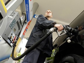 Gas pump attendant James Lewis serves a customer at a gas station in Portland, Ore., on May 6, 2015.