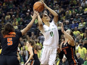 Oregon's Satou Sabally, center, shoots between Oregon State's Taya Corosdale, left, and Mikayla Pivec, right, during the first quarter of an NCAA college basketball game Sunday, Jan. 21, 2018, in Eugene, Ore.