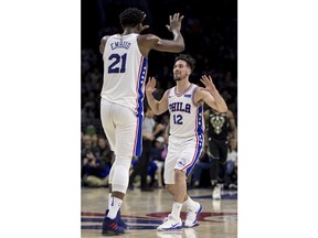 Philadelphia 76ers' Joel Embiid, left, celebrates his 3-point shot with T.J. McConnell, right, during the first half of the team's NBA basketball game against the Milwaukee Bucks, Saturday, Jan. 20, 2018, in Philadelphia.