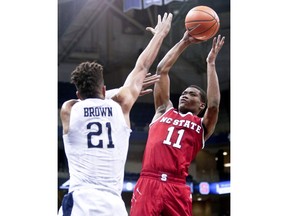 North Carolina State's Markell Johnson (11) shoots over Pittsburgh's Terrell Brown (21) during the first half of an NCAA college basketball game, Wednesday, Jan. 24, 2018, in Pittsburgh.