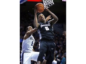 Providence forward Rodney Bullock (5) goes to the basket past Villanova guard Phil Booth (5) in the first half of an NCAA college basketball game, Tuesday, Jan. 23, 2018, in Philadelphia.