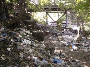 FILE - This July 31, 2017, file photo shows trash including discarded syringes and other rubbish in an open-air heroin market that has thrived for decades, slated for cleanup along train tracks a few miles outside the heart of Philadelphia. As part of Philadelphia's effort to combat skyrocketing opioid overdoses, city officials announced Tuesday, Jan. 23, 2018, they want to establish safe havens where people can inject drugs, after members of the city's opioid task force visited Seattle and Vancouver in 2017.