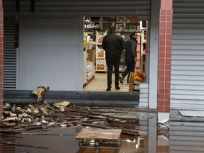 People walk in a kosher market after a fire broke out in Creteil, south of Paris, Tuesday, Jan.9, 2018. French officials say the fire broke out at the kosher market south of Paris that was vandalized with anti-Semitic graffiti last week.