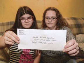 Mary Reinard, 11, and her step-mother Shannon Reinard, hold up a letter Tuesday, Jan. 30, 2018 that Mary had hoped to send to Hillary Clinton.  The Sunbury family called for a public apology on Tuesday from Shikellamy Middle School teacher Benjamin Attinger, who admits he intentionally misaddressed a letter their 11-year-old daughter had written to Hillary Clinton.