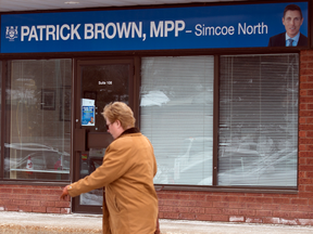 A woman walks by the Orillia office of former Ontario Progressive Conservative leader Patrick Brown who resigned amidst sexual misconduct allegations, Jan. 25, 2018.