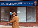 A woman walks by the Orillia office of former Ontario Progressive Conservative leader Patrick Brown who resigned amidst sexual misconduct allegations, Jan. 25, 2018.