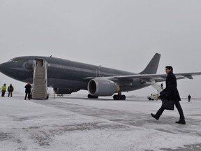 Canadian Prime Minister Justin Trudeau walks across a snow covered tarmac towards his plane as he departs Ottawa for Davos, Switzerland for the annual World Economic Forum on Monday, January 22, 2018.