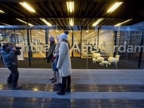 Chris, Molly and Deborah Williams, three U.K. nationals living in the Netherlands pose for a photographer outside a district court in Amsterdam, Netherlands, Wednesday, Jan. 17, 2018. Two organisations and 5 British nationals challenge the right of the British government and the European commission to negotiate away their rights as EU citizens in the Brexit talks.