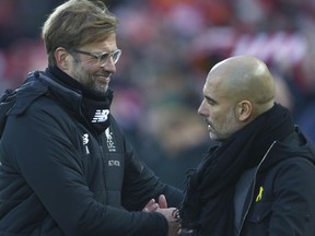 Liverpool's manager Juergen Klopp, left, shakes hands with Manchester City's manager Pep Guardiola prior to the English Premier League soccer match between Liverpool and Manchester City at Anfield Stadium, in Liverpool, England, Sunday Jan. 14, 2018.