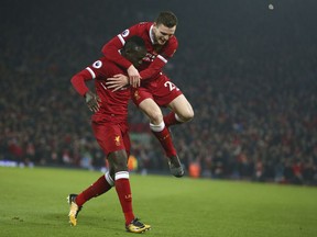 Liverpool's Sadio Mane, left, celebrates with Liverpool's Andrew Robertson after Mane scored his side's third goal during the English Premier League soccer match between Liverpool and Manchester City at Anfield Stadium, in Liverpool, England, Sunday Jan. 14, 2018.