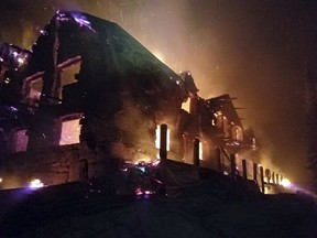 FILE- This Aug. 31, 2017, file image from video provided by the Hutton Incident Team shows the historic main Sperry Chalet building engulfed in flames in Glacier National Park, Mont. Some Montana companies hope to keep the fame of the spruce tree that served as the U.S. Capitol Christmas Tree alive by trucking the tree back home to Montana. Organizers hope it can be used to help rebuild a century-old chalet in Glacier National Park that was destroyed in a wildfire last summer.