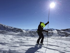 This April, 2017, photo provided by the Alaska Division of Geological and Geophysical Surveys shows geologist Katreen Wikstrom Jones using an avalanche probe to measure snow depth at Thompson Pass, Alaska. Researchers in the Pacific Northwest and Alaska are looking for backcountry enthusiasts who want to aid a science mission. A program funded by NASA is recruiting citizen scientists to measure snow levels in mountain terrain.