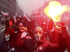 Far-right nationalists burn flares as they march in large numbers through the streets of Warsaw to mark Poland's Independence Day in Warsaw, Poland, on Nov. 11, 2016. Three people have been charged with propagating fascism after a news program revealed details about a neo-Nazi group in Poland that celebrated Adolf Hitler in a ceremony last year.