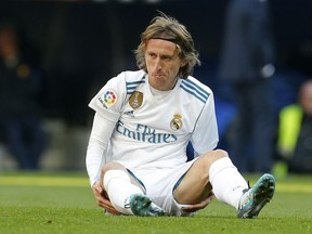 In this photo taken on Dec. 23, 2017, Real Madrid's Luka Modric sits on the pitch after falling during the Spanish La Liga soccer match between Real Madrid and Barcelona at the Santiago Bernabeu stadium in Madrid, Spain. Croatia midfielder Luka Modric has appeared in court in a tax fraud case in Madrid on Tuesday Jan. 9, 2018, accused of defrauding tax authorities of 870,728 euros (about 1 million dollars) in 2013 and 2014. Local newspaper El Mundo said Modric has already paid nearly 1 million (1.2 million dollars) to tax authorities to try to reach a settlement.