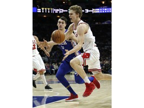 Chicago Bulls forward Lauri Markkanen, right, is fouled by Philadelphia 76ers forward Dario Saric (9) during the first half on an NBA basketball game Wednesday, Jan. 24, 2018, in Philadelphia.