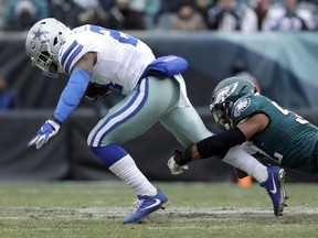 Dallas Cowboys' Ezekiel Elliott, left, is tackled by Philadelphia Eagles' Najee Goode during the first half of an NFL football game, Sunday, Dec. 31, 2017, in Philadelphia.