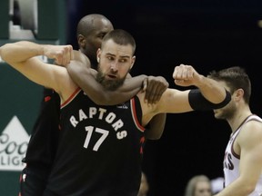 Toronto Raptors' centre Jonas Valanciunas gets a bear hug from teammate Serge Ibaka during NBA action Friday night in Milwaukee. Valanciunas had 20 points and nine rebounds as the Raptors defeated the hometown Bucks 129-110.