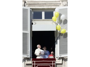 Pope Francis looks at the balloons that had been stuck in the window as they get released during the Angelus noon prayer in St. Peter's Square at the Vatican, Sunday, Jan. 28, 2018. Francis in remarks to faithful denounced the suicide bombing that killed more than 100 in Kabul a day earlier and another recent deadly strike in the Afghan capital.