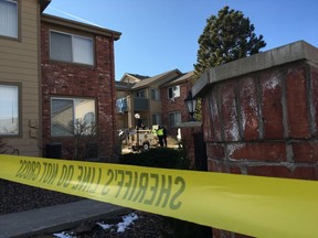 Sheriff's deputies remove a spotlight, Monday, Jan. 1, 2018, used to help investigators processing evidence at an apartment where Matthew Riehl allegedly fatally shot Douglas County Sheriff's Deputy Zackari Parrish and wounded six others in the Denver suburb of Highlands Ranch, on Sunday.