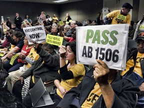Voters hold signs demonstrating their support for legislation that would allow California communities to expand rent control policies during a legislative hearing in Sacramento, Calif., on Thursday, Jan. 11, 2018. The proposal would repeal a law known as the Costa-Hawkins Act that limits cities' ability to adopt rent control measures on properties built after 1995.