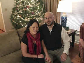 In this Jan. 4, 2018 photo, Megan Olson, 33, poses with her husband, Luke Olson, at their home in Robbinsdale, Minn. After being secretly adopted away from South Korea as a baby, Megan Olson is among the dozens of adoptees who are returning to their birth country for the 2018 Winter Games in Pyeongchang. Their visit during a celebratory time also forces South Korea to confront its international adoption phenomenon that peaked in the 1980s.